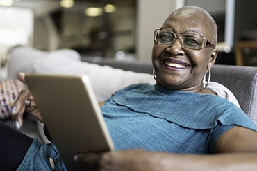 A woman holding an open laptop computer.